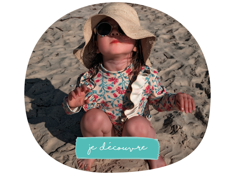 bébé sur la plage avec lunettes de soleil et chapeau
